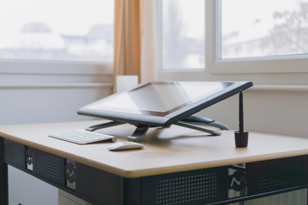 A digital drawing tablet on an adjustable stand in a bright studio, the kind of tool used for animation
